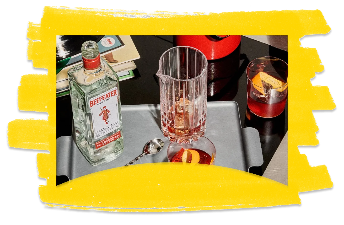 A bottle of Beefeater gin and cocktail glasses against a yellow textured background.